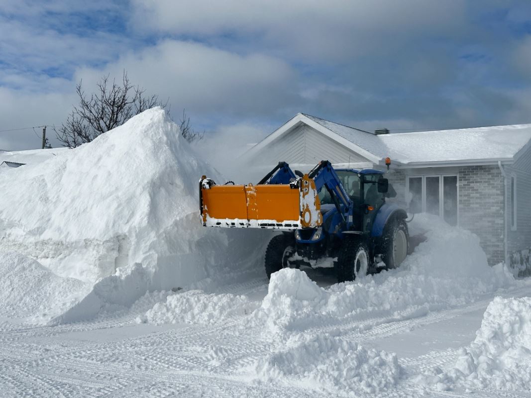 Une souffleuse à neige dans une entrée de maison.