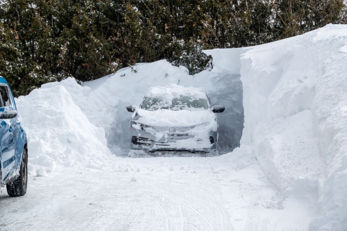 Un banc de neige dégagé autour d'une voiture. 