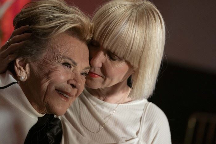 L'animatrice Pénélope McQuade pose sa main sur la tête de Janette Bertrand en lui faisant une accolade. 