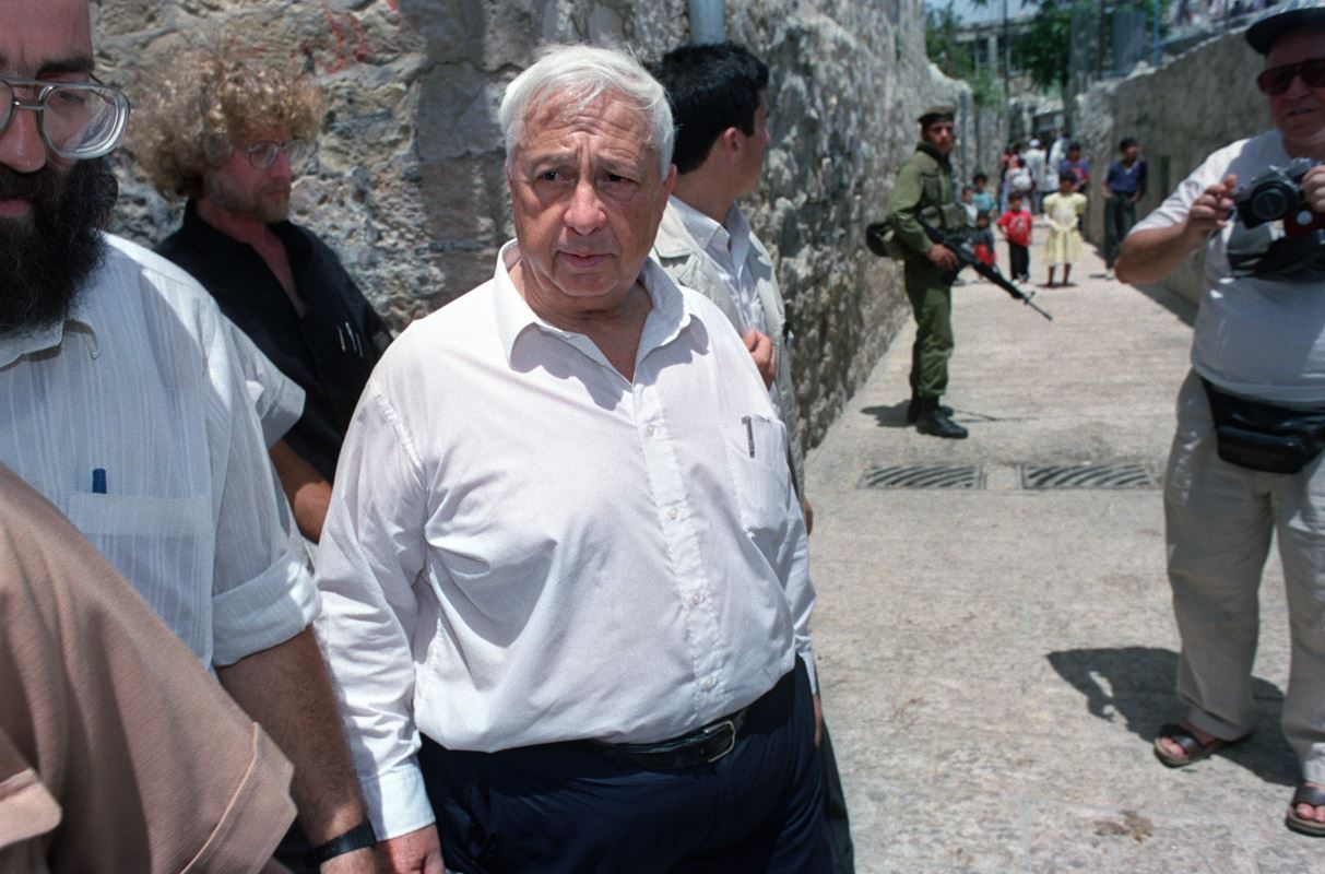 (31 mai 1992) Le ministre du Logement et de la Construction Ariel Sharon visite les quartiers arabes de la ville de Jérusalem durant les commémorations du 25e anniversaire de la « réunification » d’Israël, selon le calendrier juif. 