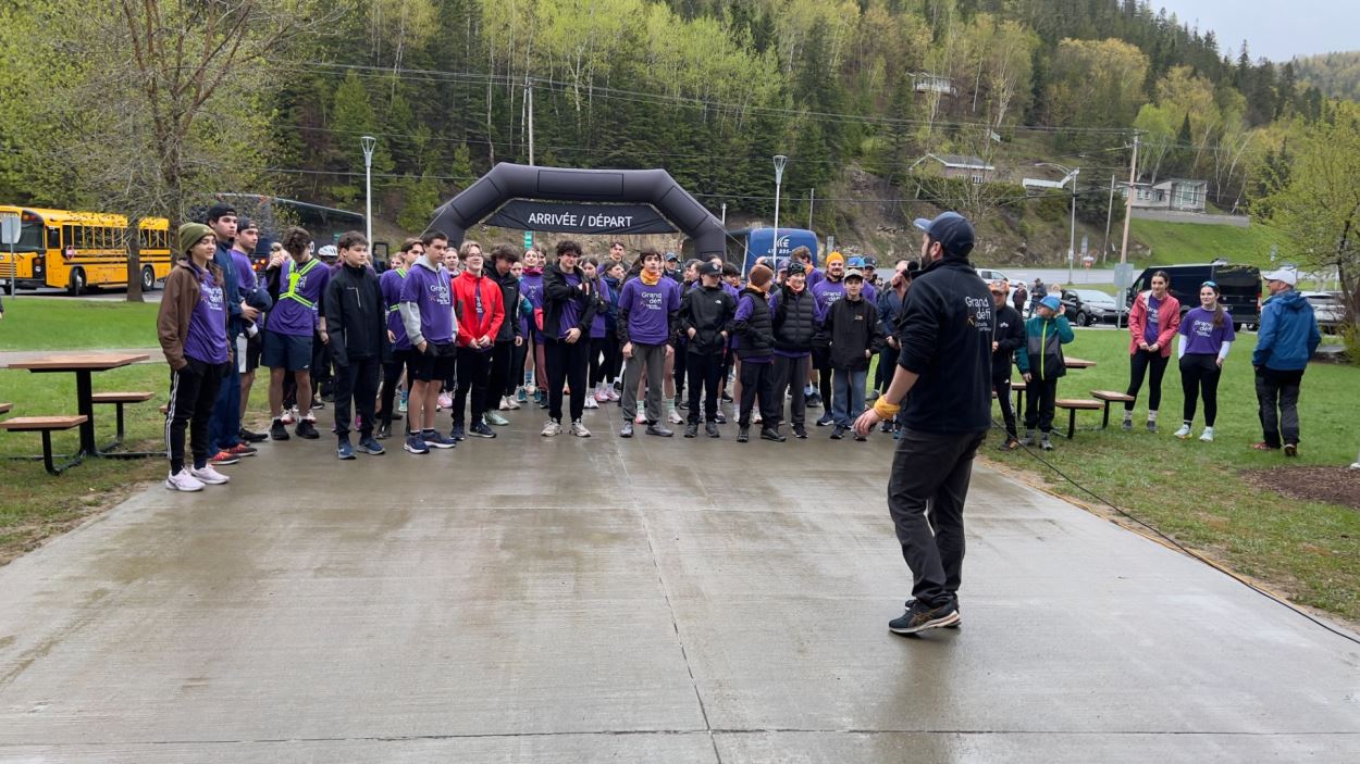 Un animateur motive une foule de jeunes devant le début de la course. 
