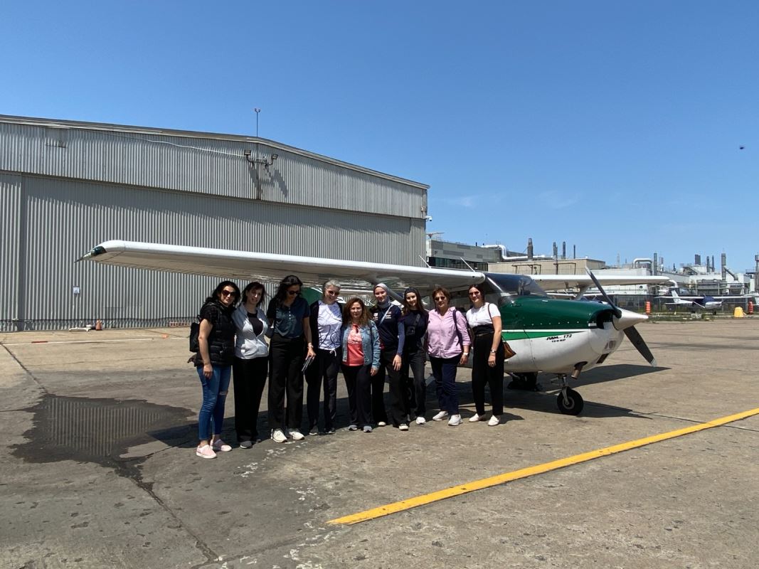 Des femmes sous l'aile d'un avion. نساء واقفات تحت جناح طائرة.
