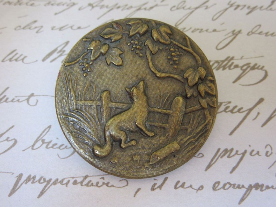 Un bouton datant de la fin de l'époque victorienne arbore une image représentant une fable de Lafontaine. Il s'agit de la fable Le renard et les raisins. On voit sur le bouton un renard dans un champ qui se tient en-dessous d'une vigne remplie de raisins.